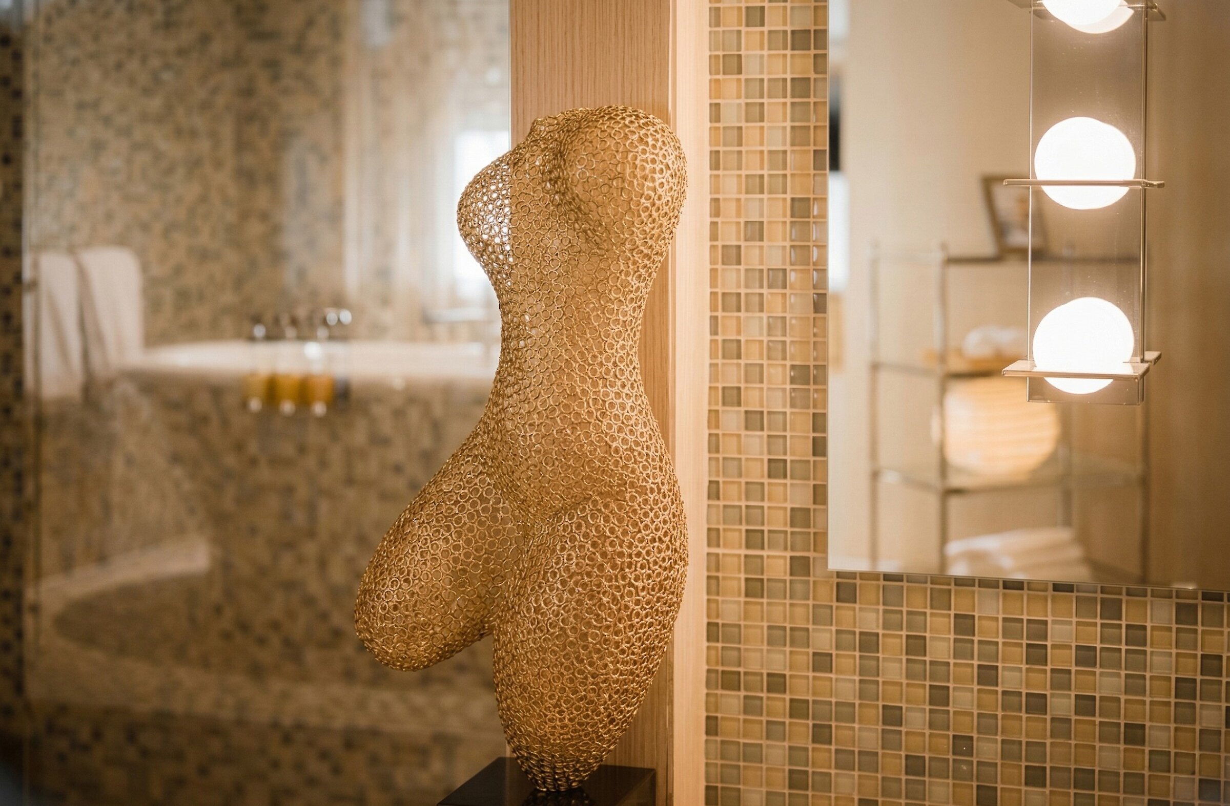 Salle de bain moderne avec mosaïque, baignoire et détail artistique élégant.