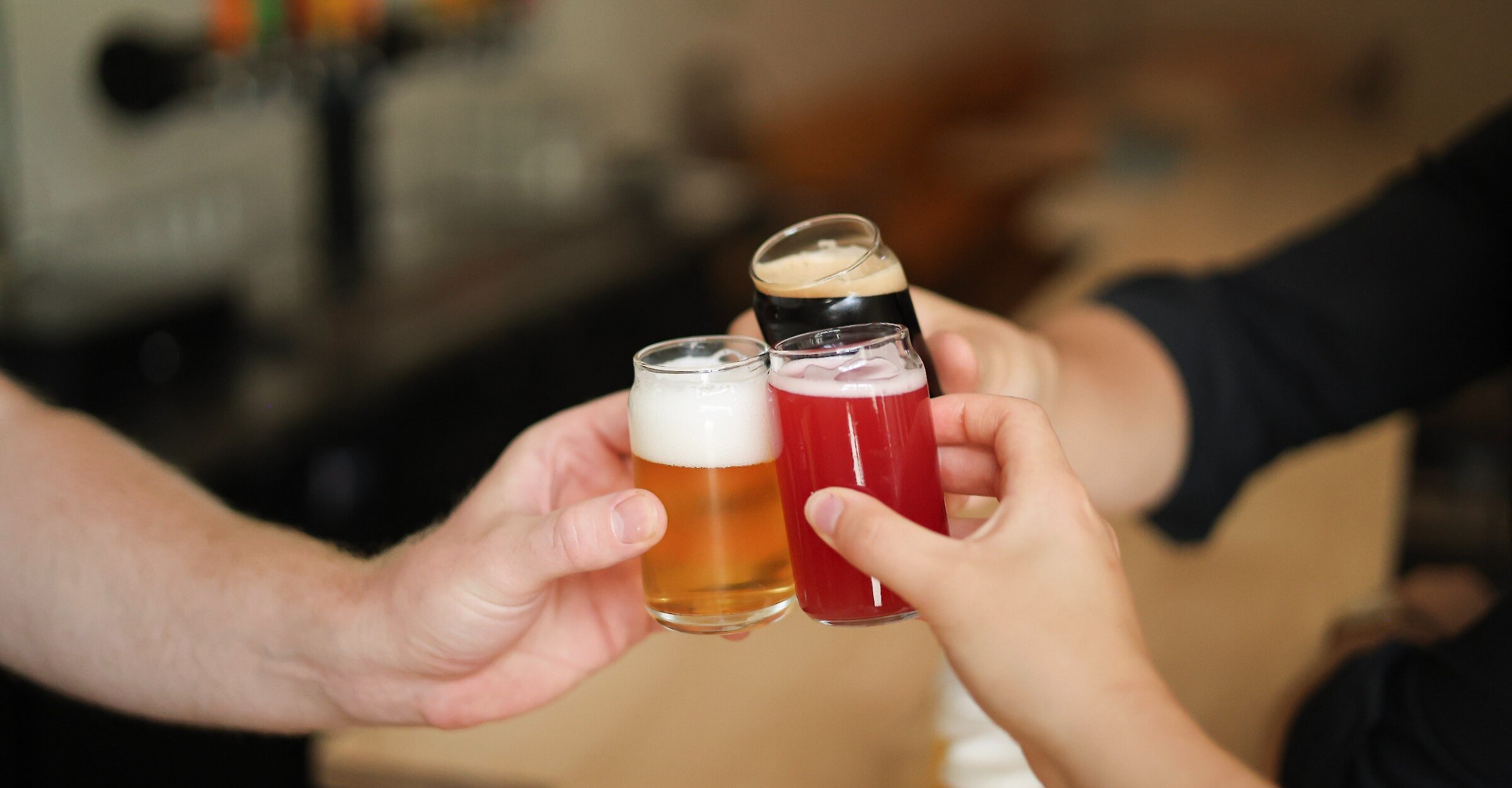 three people cheering beer together
