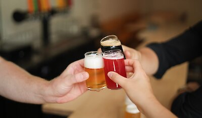 Trois personnes portent un toast avec de la bière