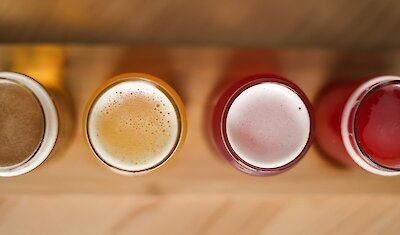 A selection of freshly crafted beverages viewed from above, showcasing a variety of vibrant colors and frothy textures.