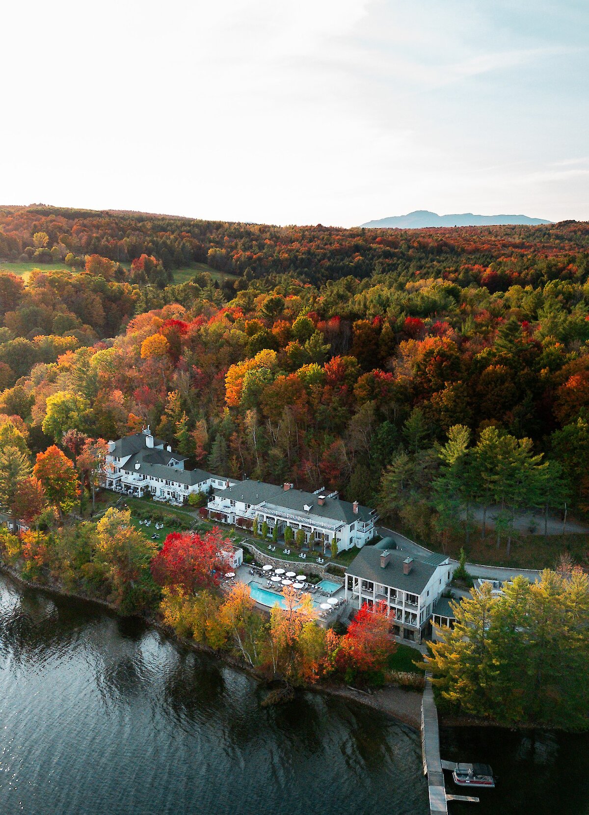 Vue aérienne du Manoir Hovey sur les rives du lac Massawippi, entouré des forêts des Cantons-de-l'Est.