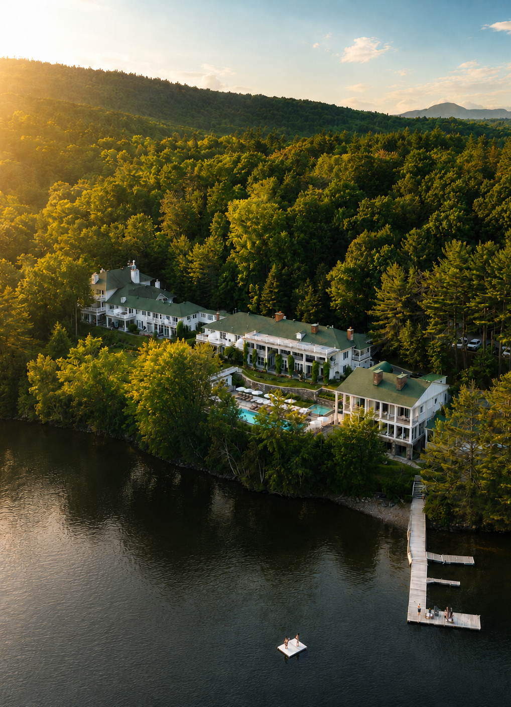 Vue aérienne du Manoir Hovey sur les rives du lac Massawippi, entouré des forêts des Cantons-de-l'Est.