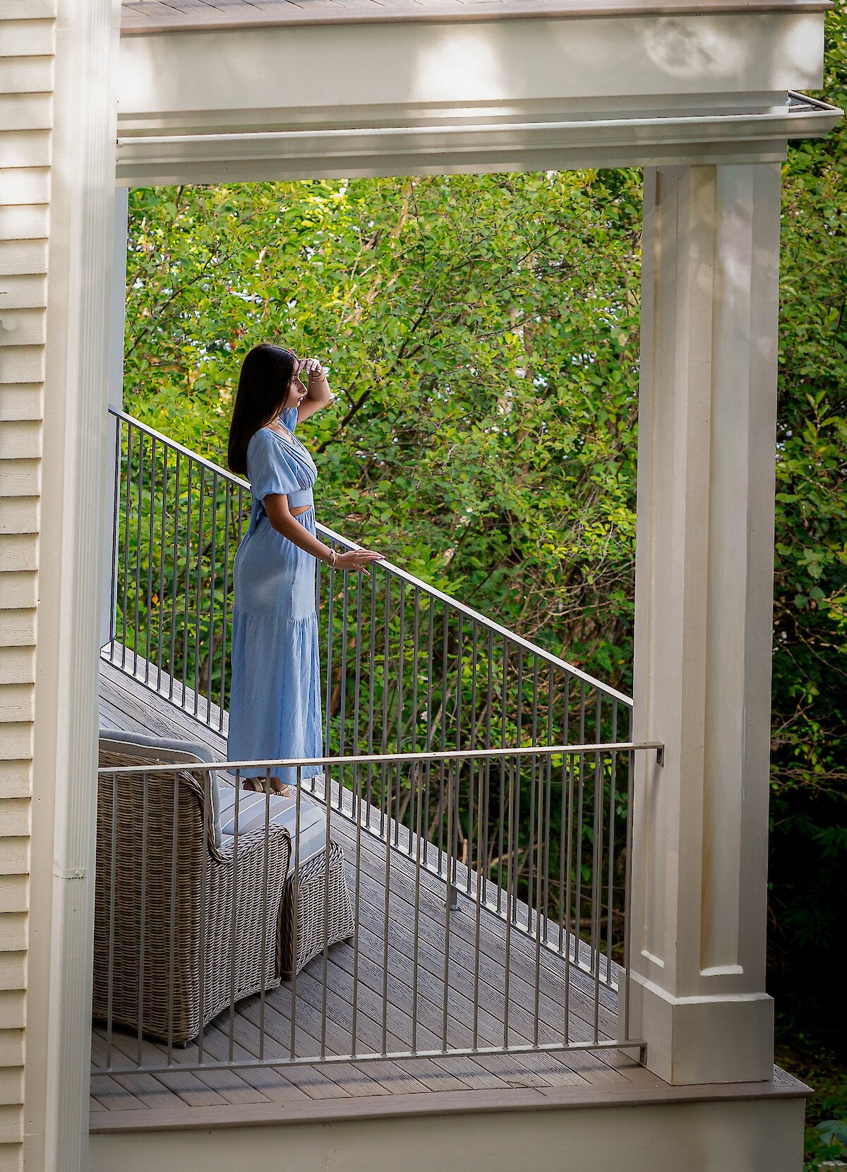 Une femme regarde la vue depuis son balcon.