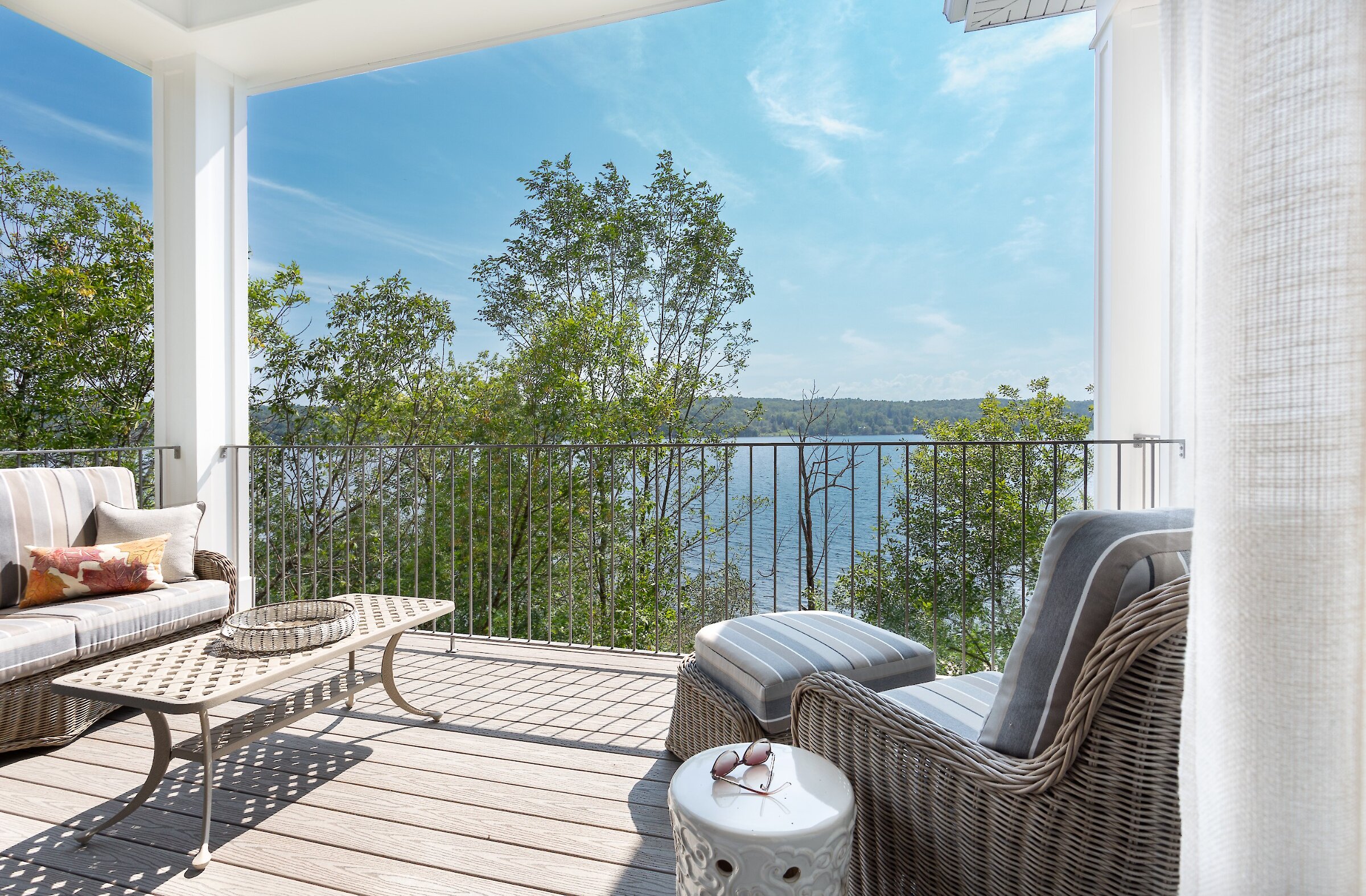 Balcon privé avec mobilier extérieur et vue panoramique sur le lac.