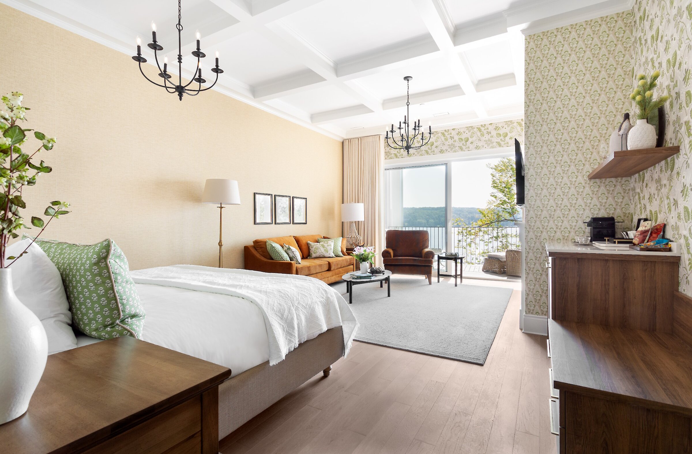 Chambre spacieuse avec lit, foyer, coin salon et plafond voûté.