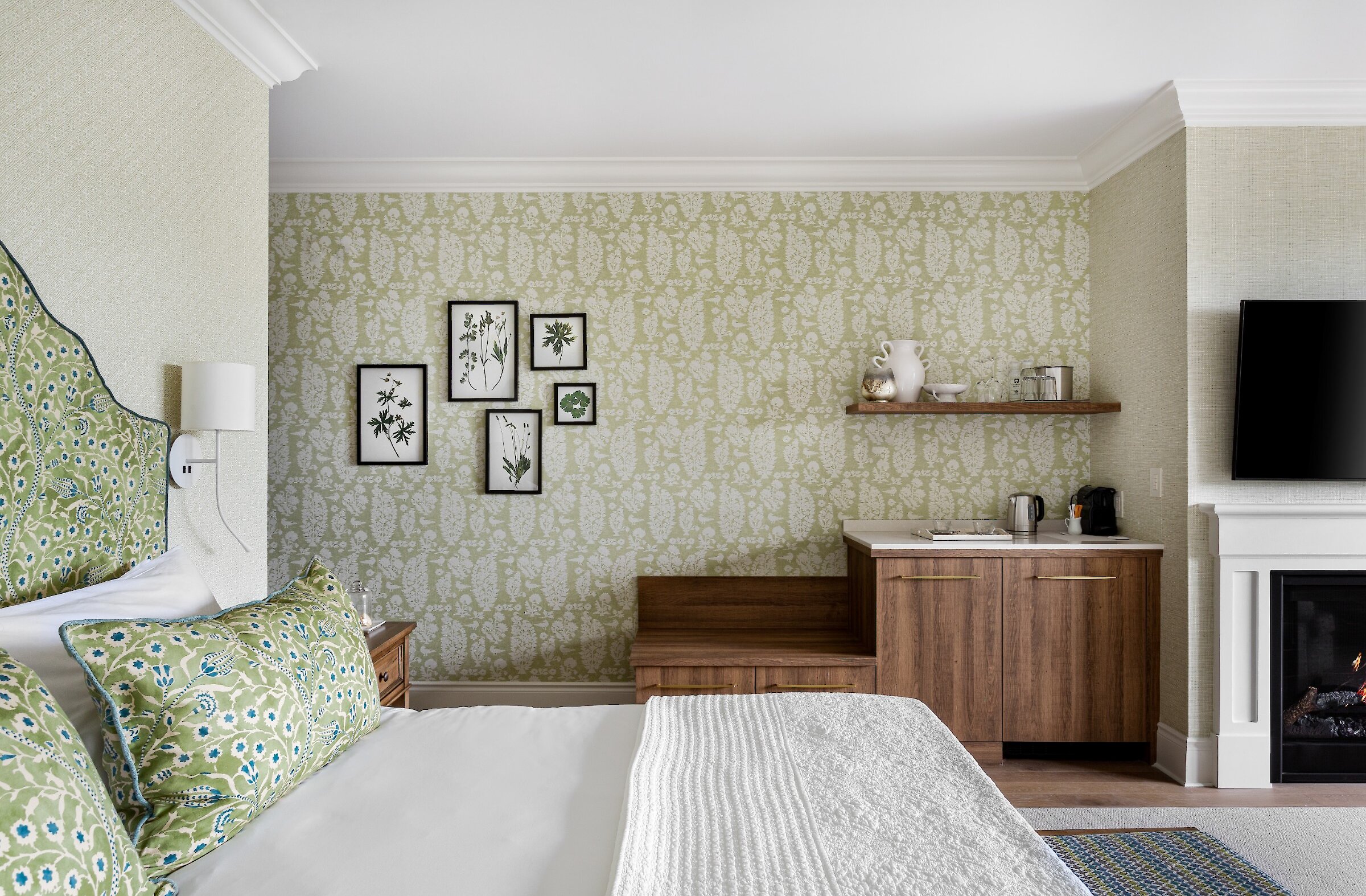 Chambre avec lit, foyer, téléviseur et espace rafraîchissements intégré.