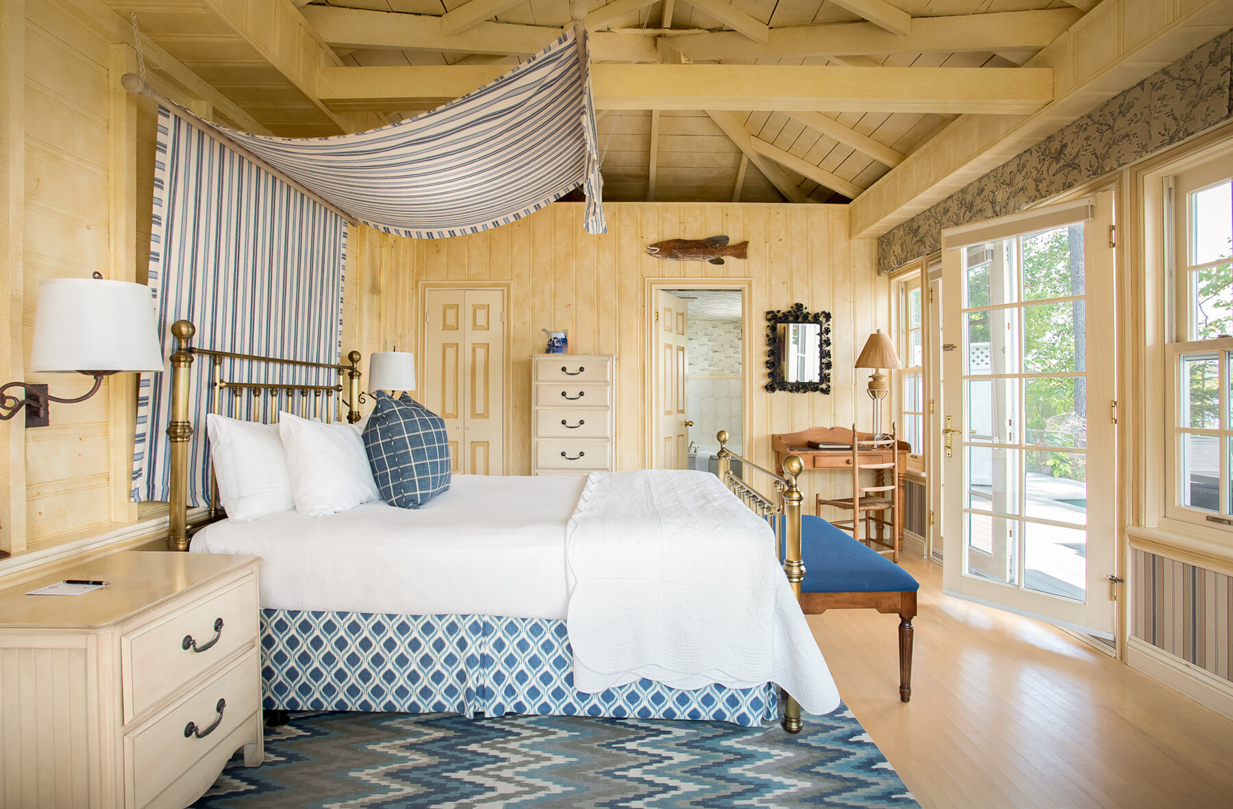 Chambre avec lit à baldaquin et vue sur le lac.
