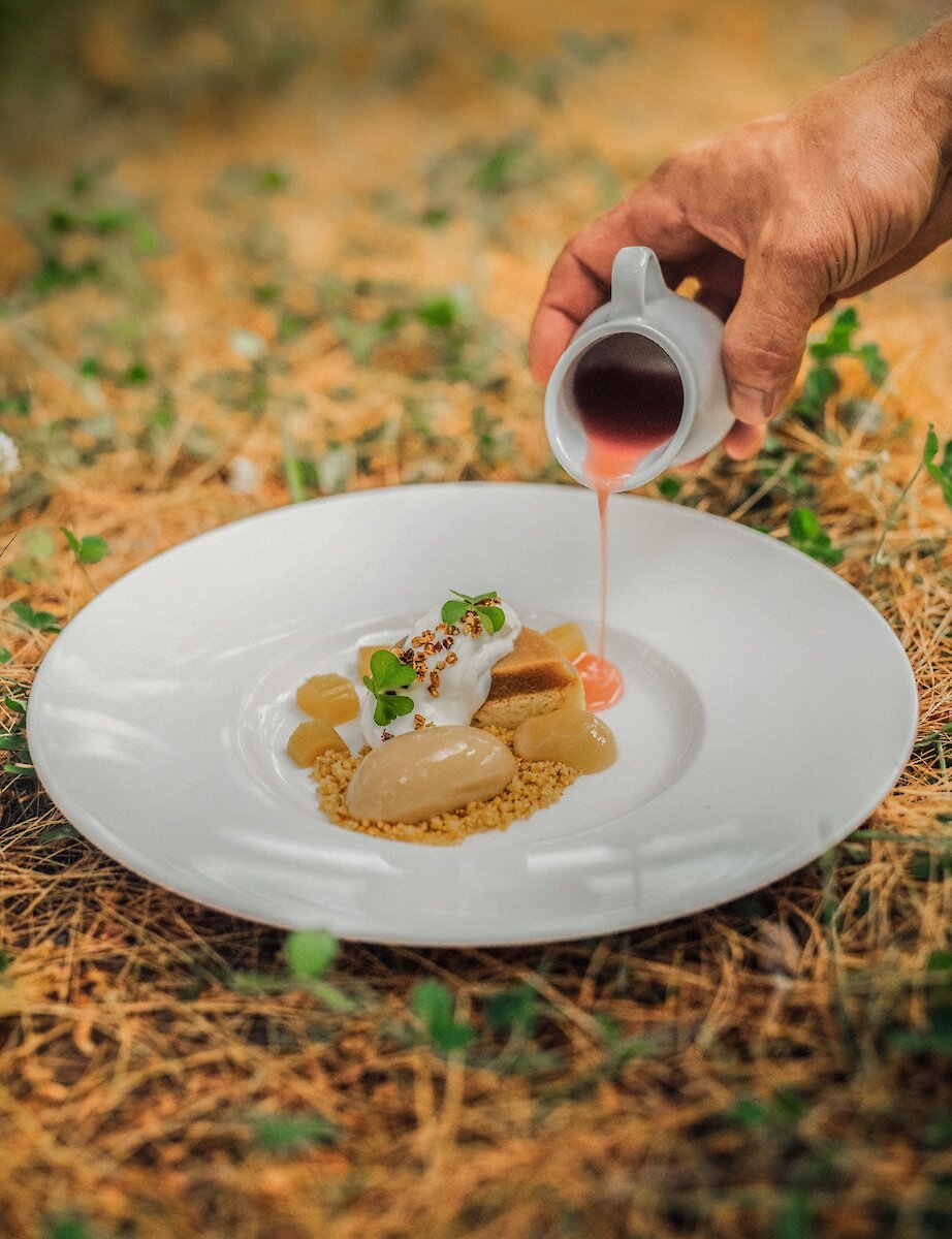 Un dessert raffiné dressé en pleine nature, sublimé par une sauce versée à la main.