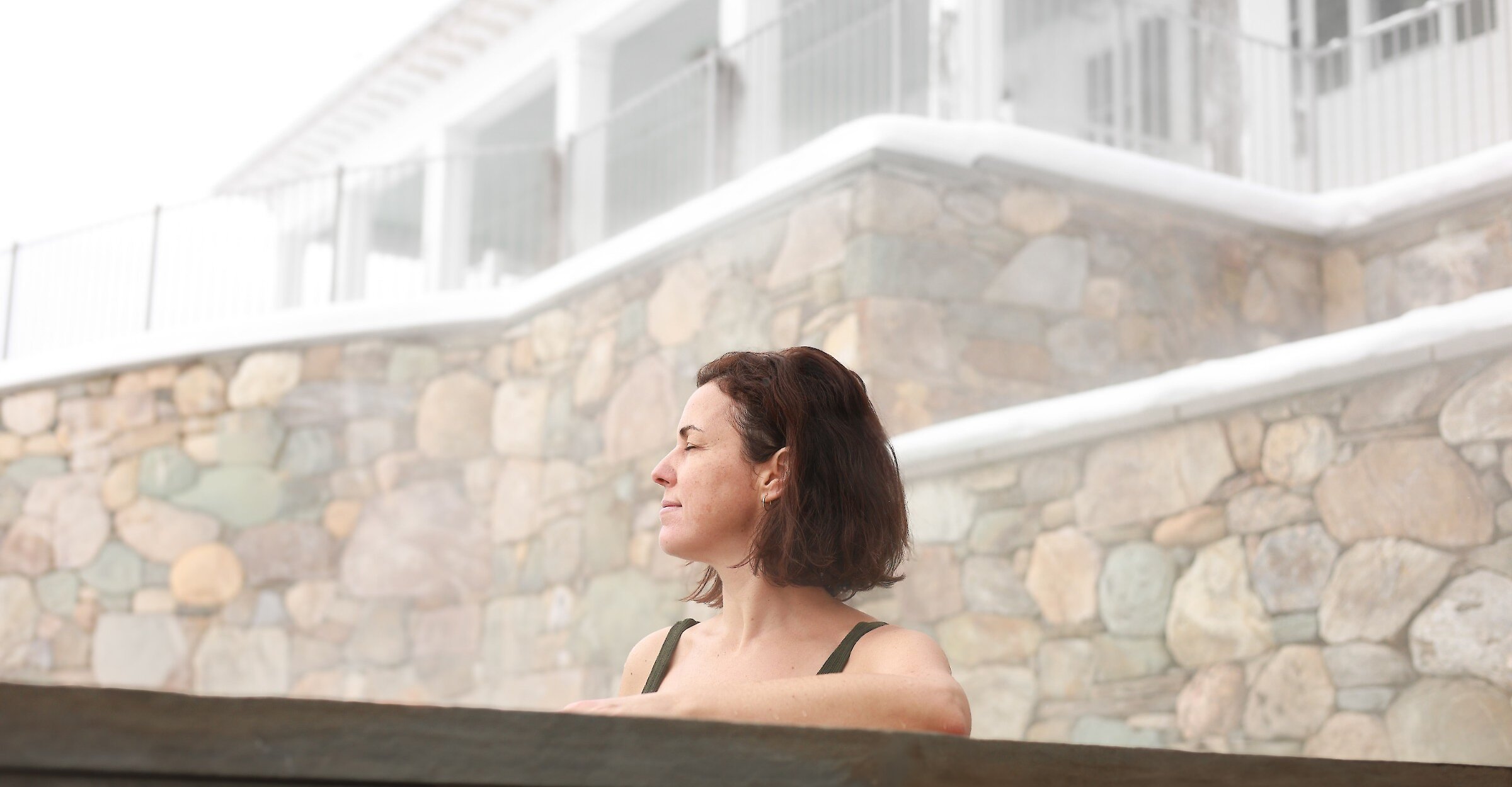 A woman in a hot tub in winter.
