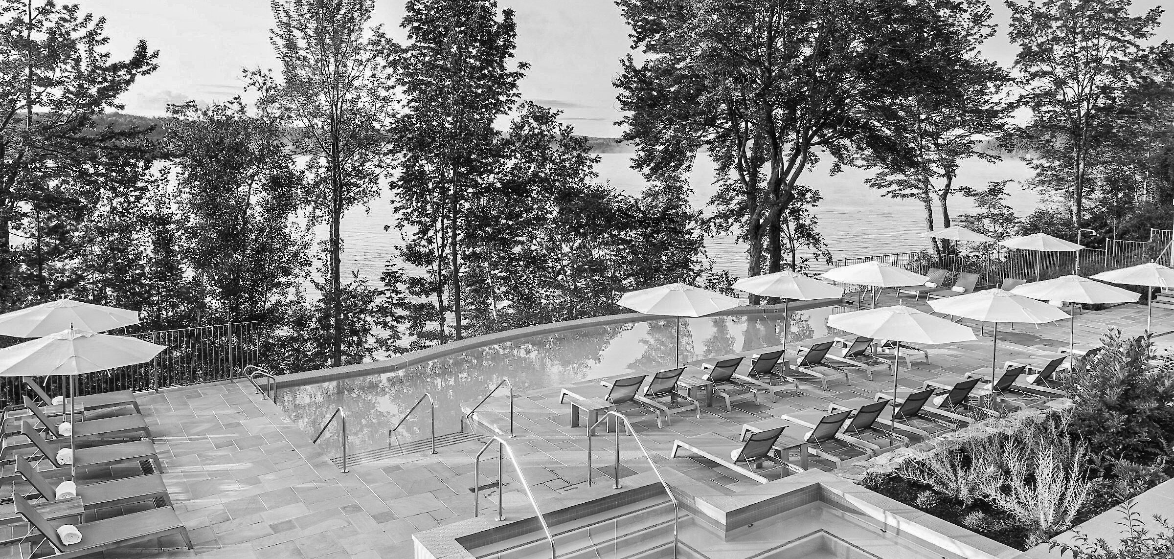 Vue de la piscine à débordement sur le lac devant l'hôtel