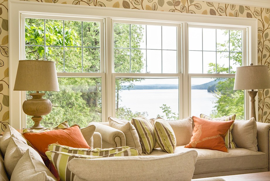 Salon avec canapé et fenêtres qui offrent une vue du lac