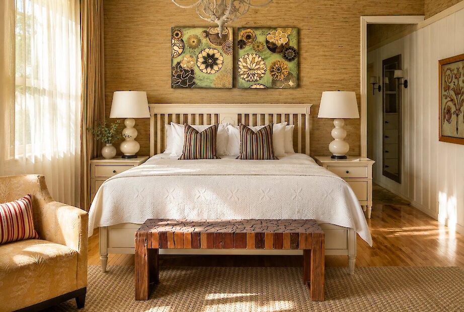 A spacious and elegantly appointed guest room featuring soft natural tones, refined furnishings, and abundant daylight, creating a warm and inviting retreat.