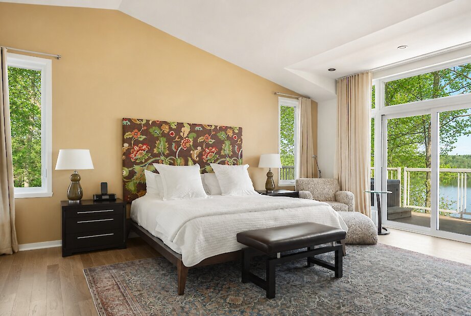 Spacious modern suite with large windows and a balcony.