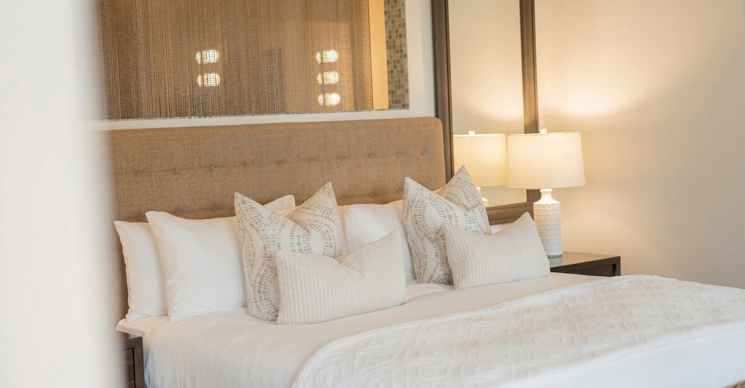 Elegant room with king bed, upholstered headboard, soft and bright ambiance.