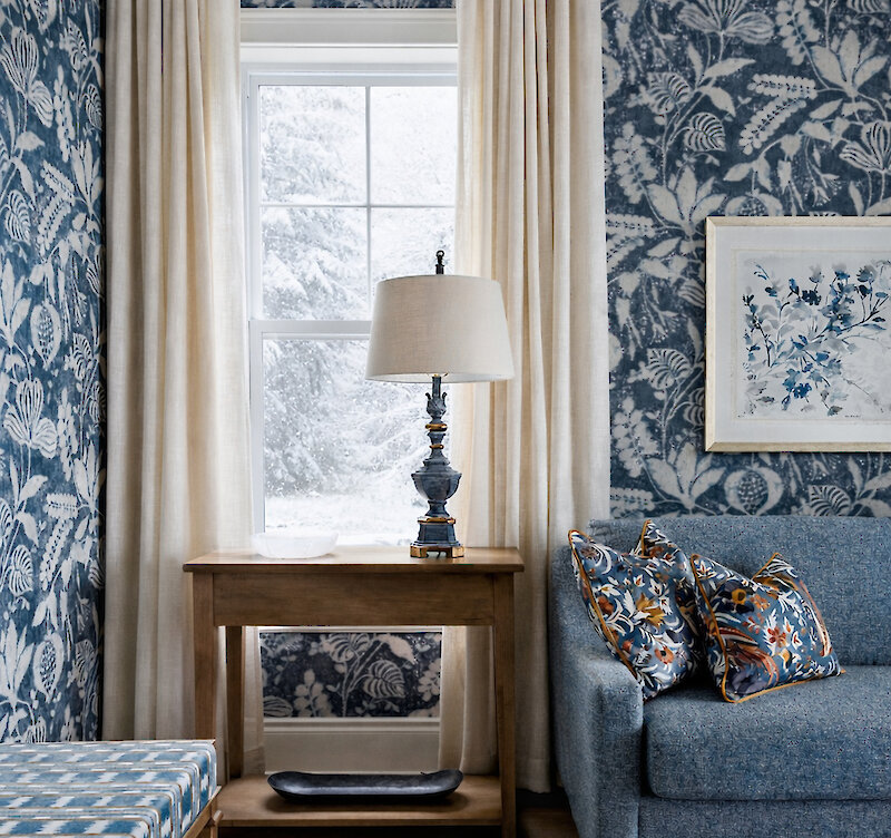 A sofa and a lamp next to a window