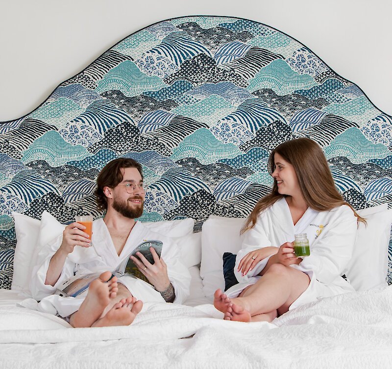 A couple taking coffee in bed.