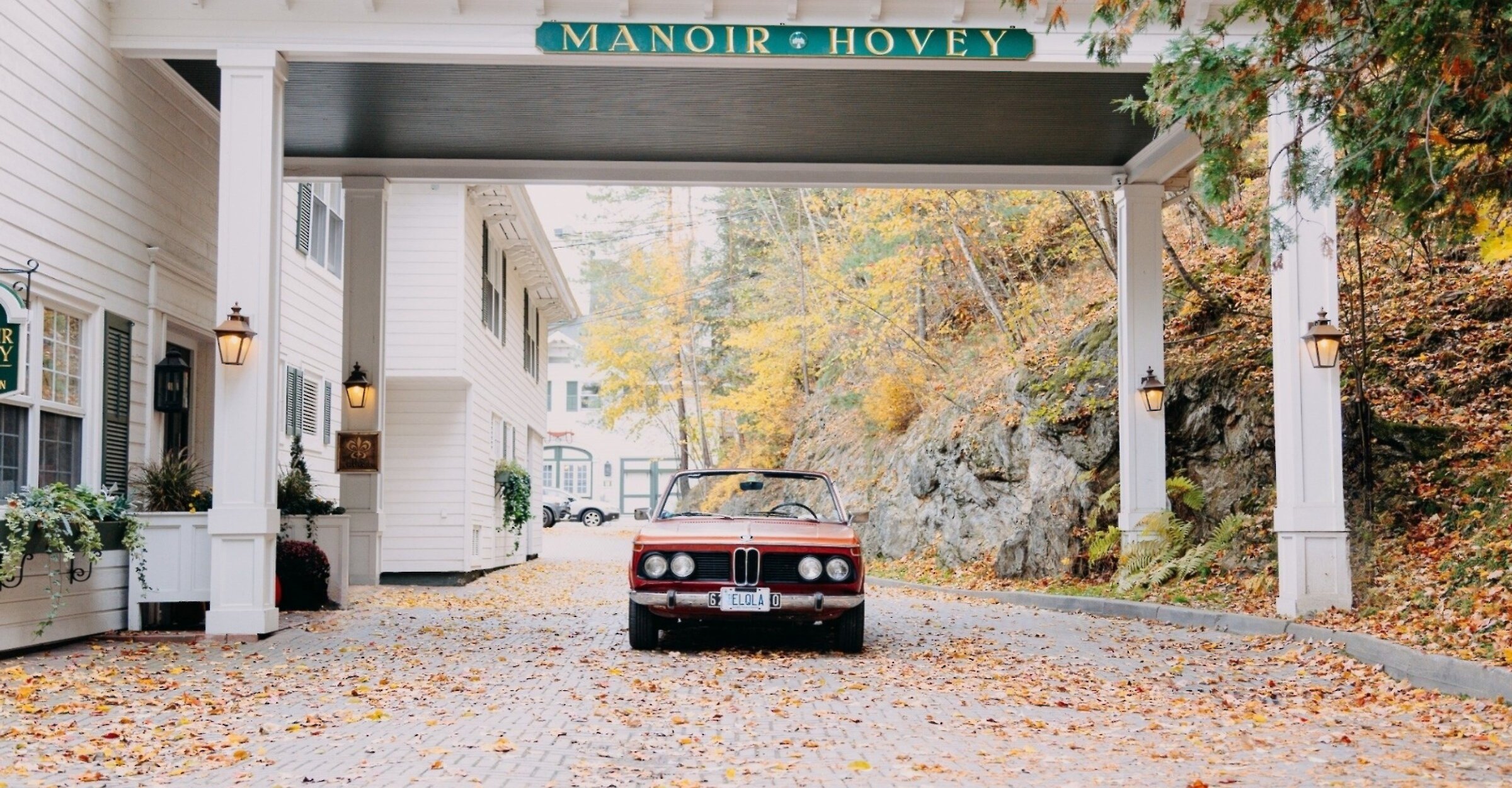 A vintage car at the entrance of the Manoir