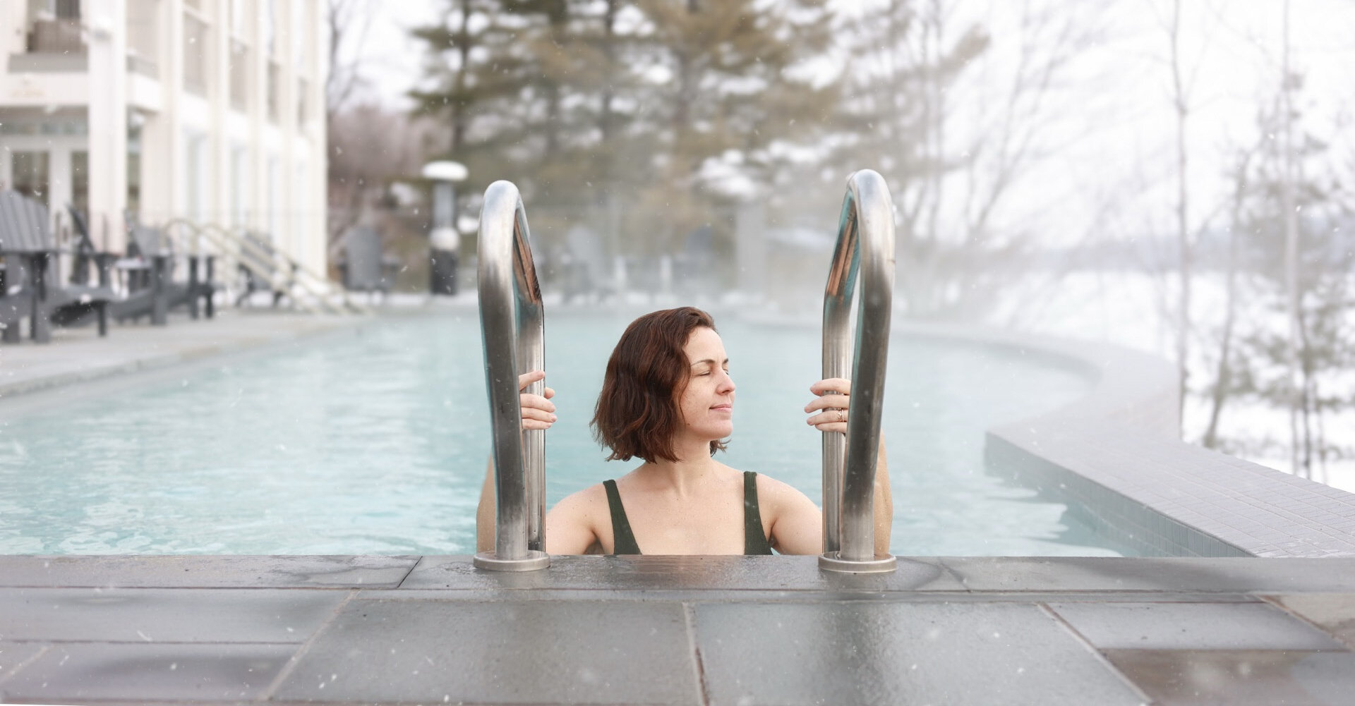 Femme entrant dans une piscine extérieure chauffée en hiver.