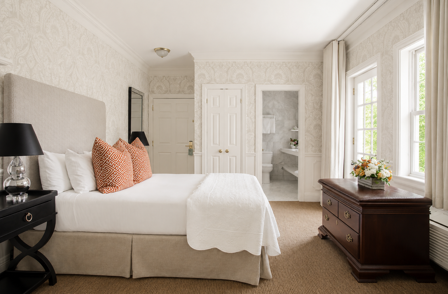 Chambre lumineuse au décor classique avec salle de bain en marbre.