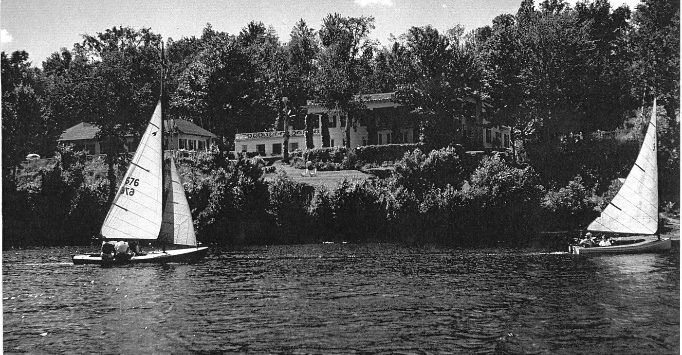 Vintage photo with two sailboats floating in front of the Manoir