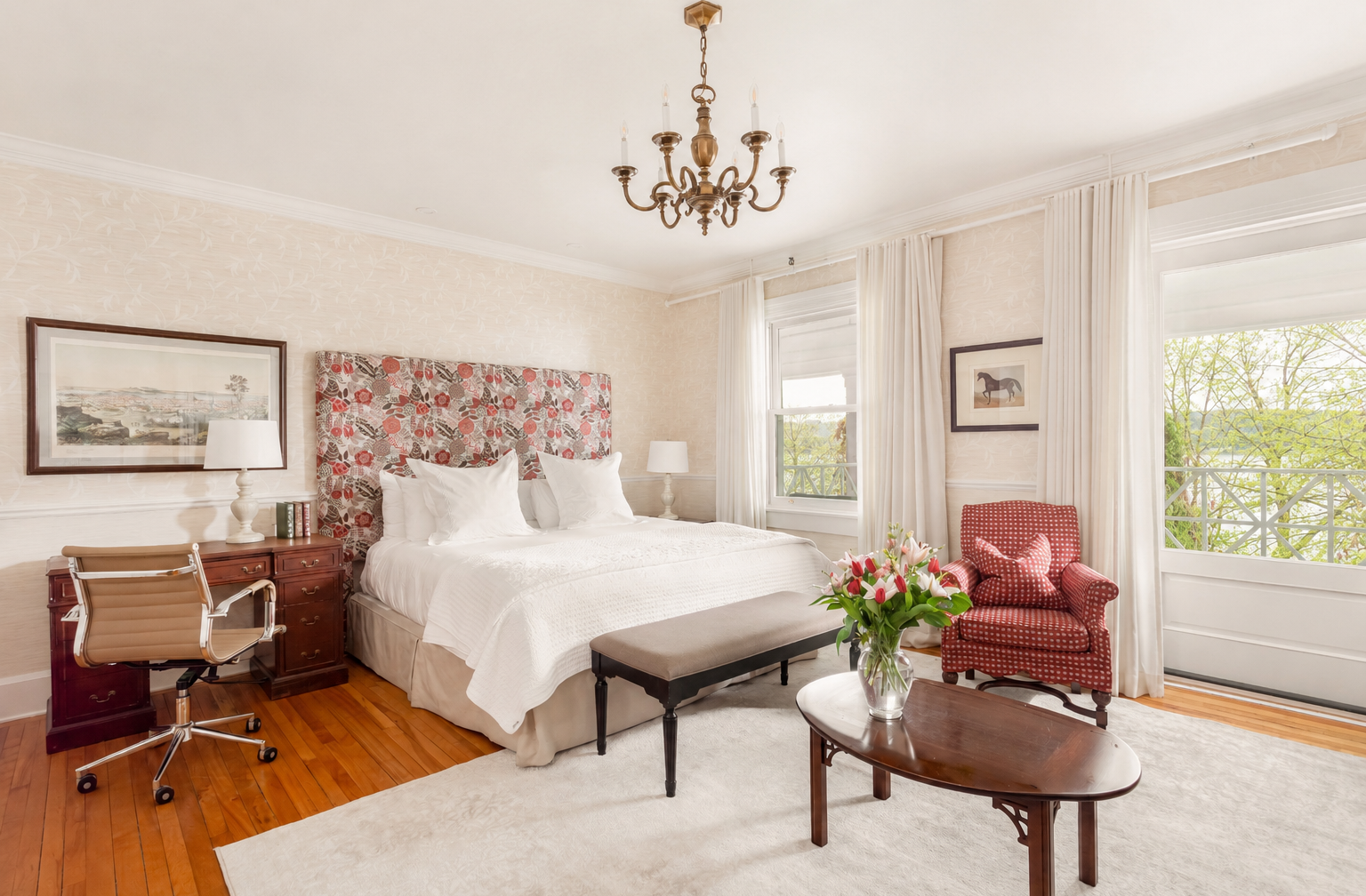 Chambre spacieuse aux accents floraux, planchers de bois et vue sur le lac.