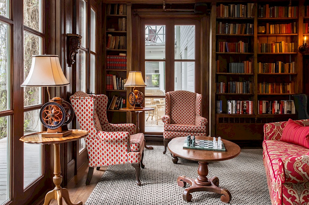 Bibliothèque au charme ancien avec de nombreux livres, des canapés et de grandes fenêtres