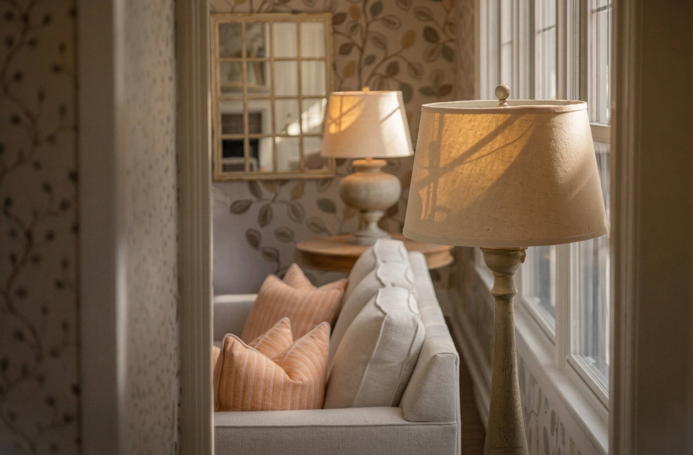 Canapé avec coussins, lampe et fenêtre avec lumière naturelle.