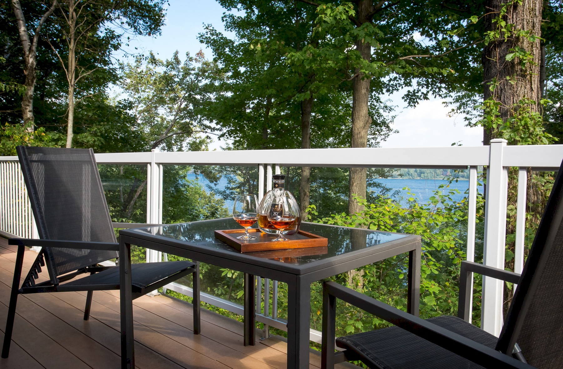 Balcon avec vue sur le lac et une table avec des chaises