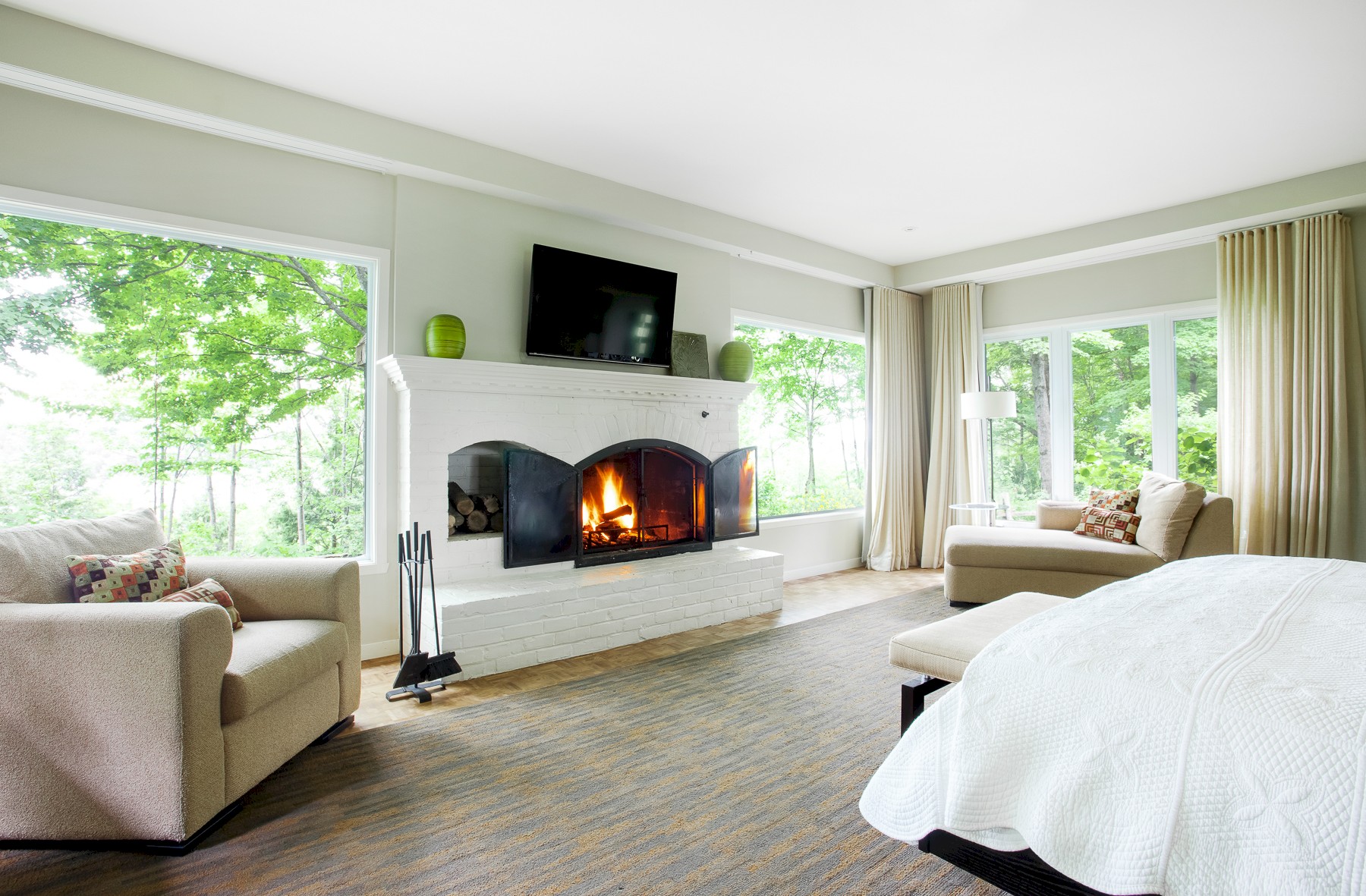 Modern room with lots of windows and a fireplace.