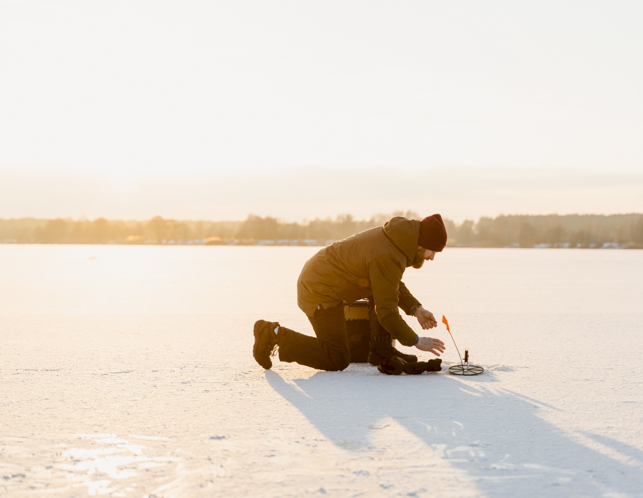 Un homme fait de la pêche sur la glace sur le lac