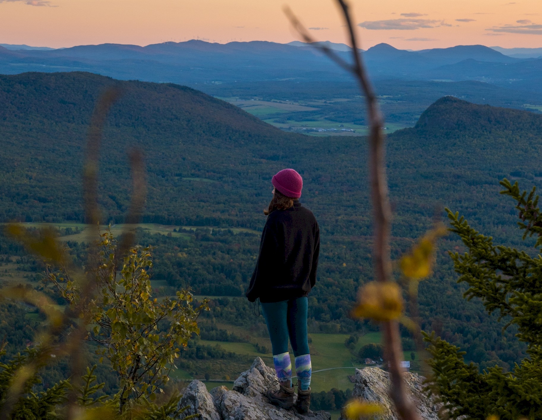 A woman enjoys the view from the top of a hill while hiking
