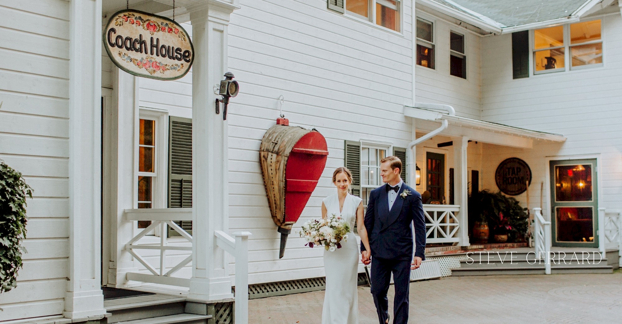 Groom and bride walking in front of the Coach House