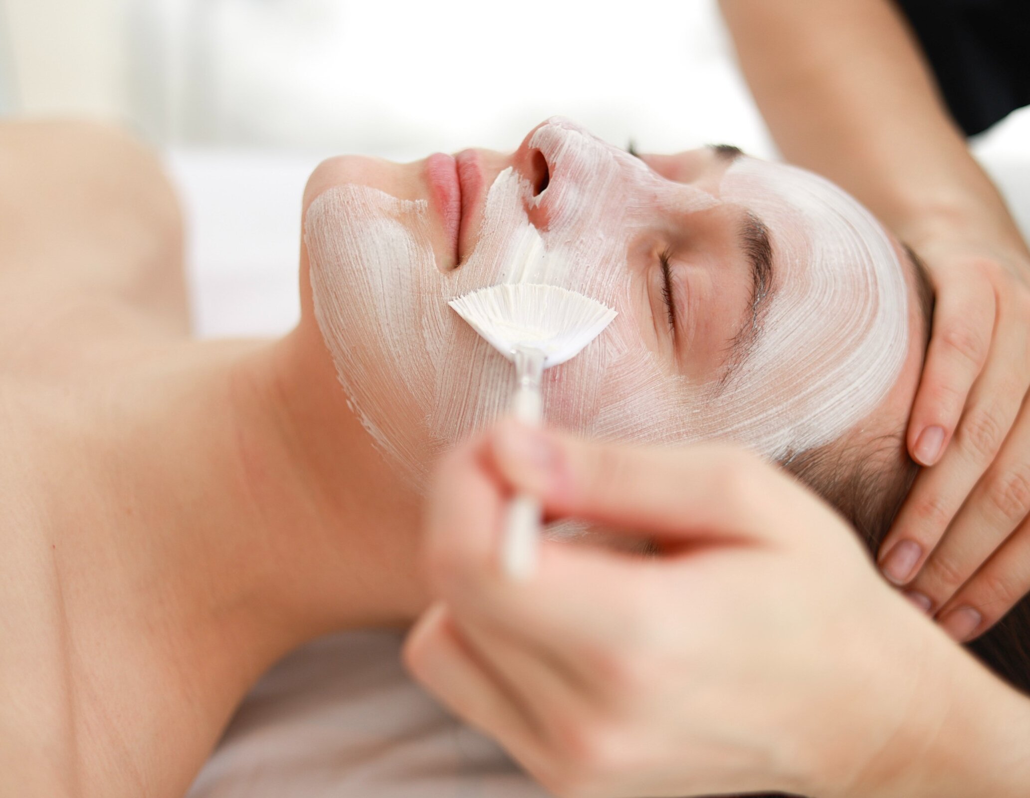Une femme fait un soin du visage au spa.