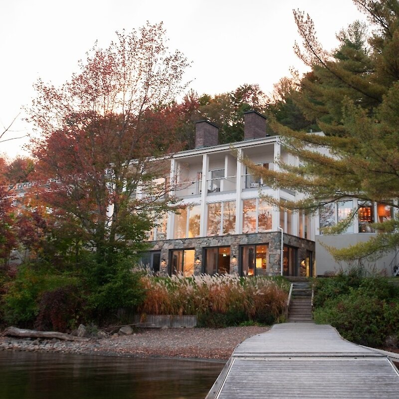 A building on the shores of a lake at sunset