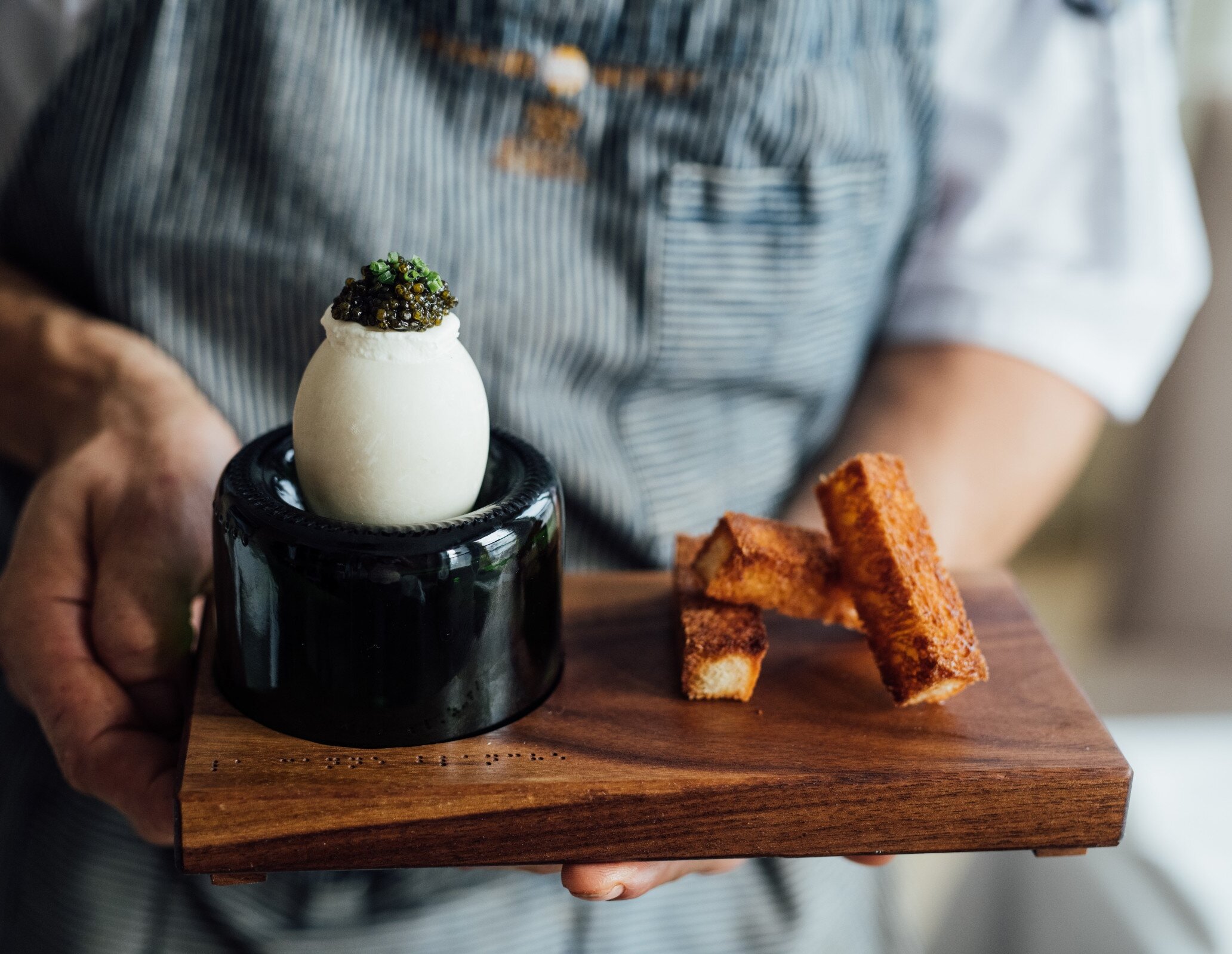 A duck egg presented on a wooden tray