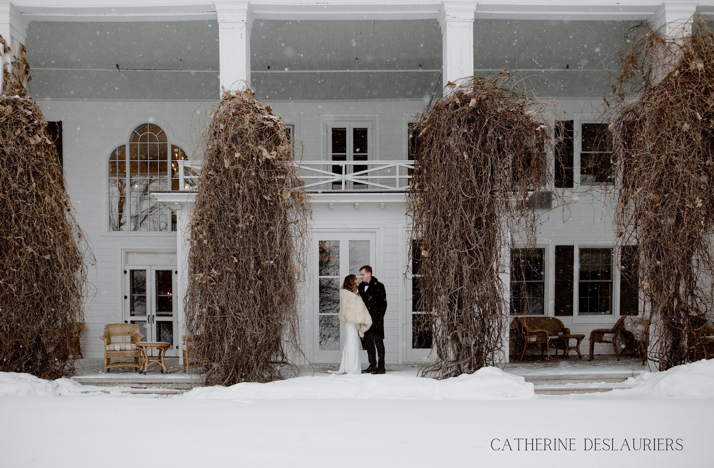 Two guests under the snowflakes in front of the main building