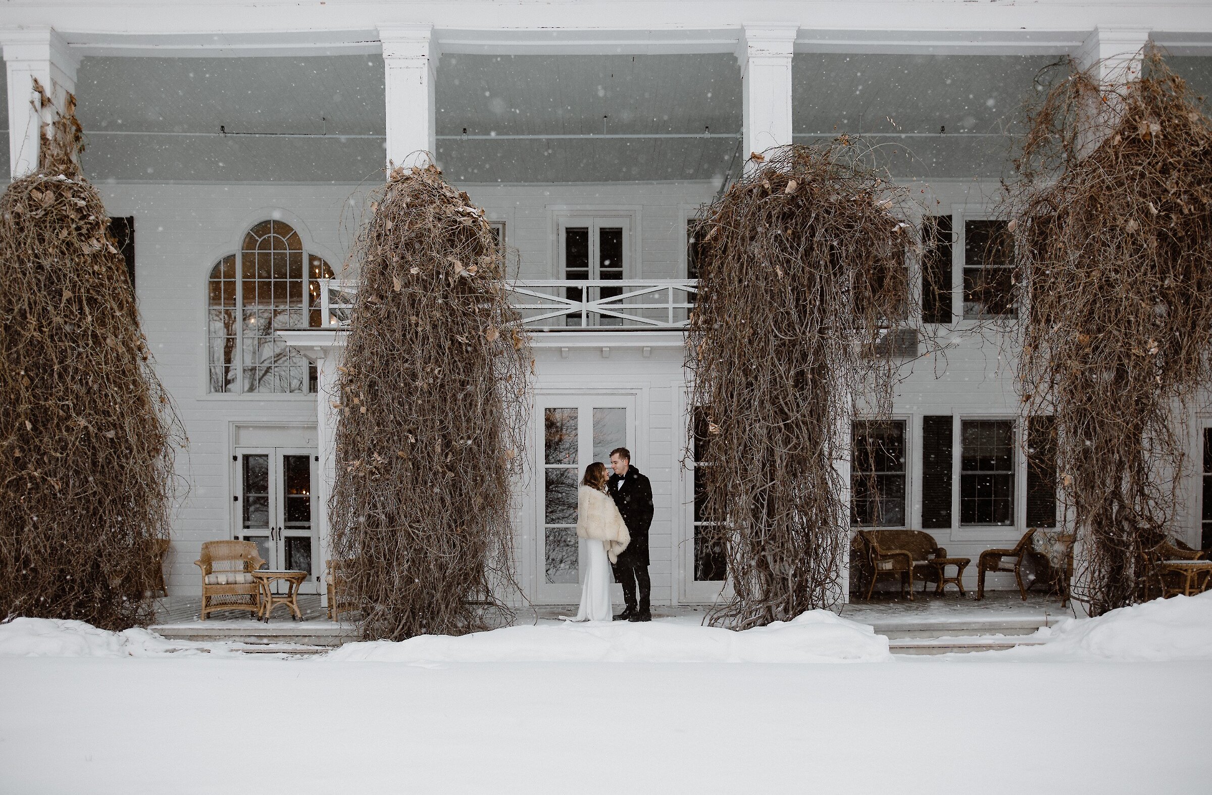Two guests in front of the manor during winter