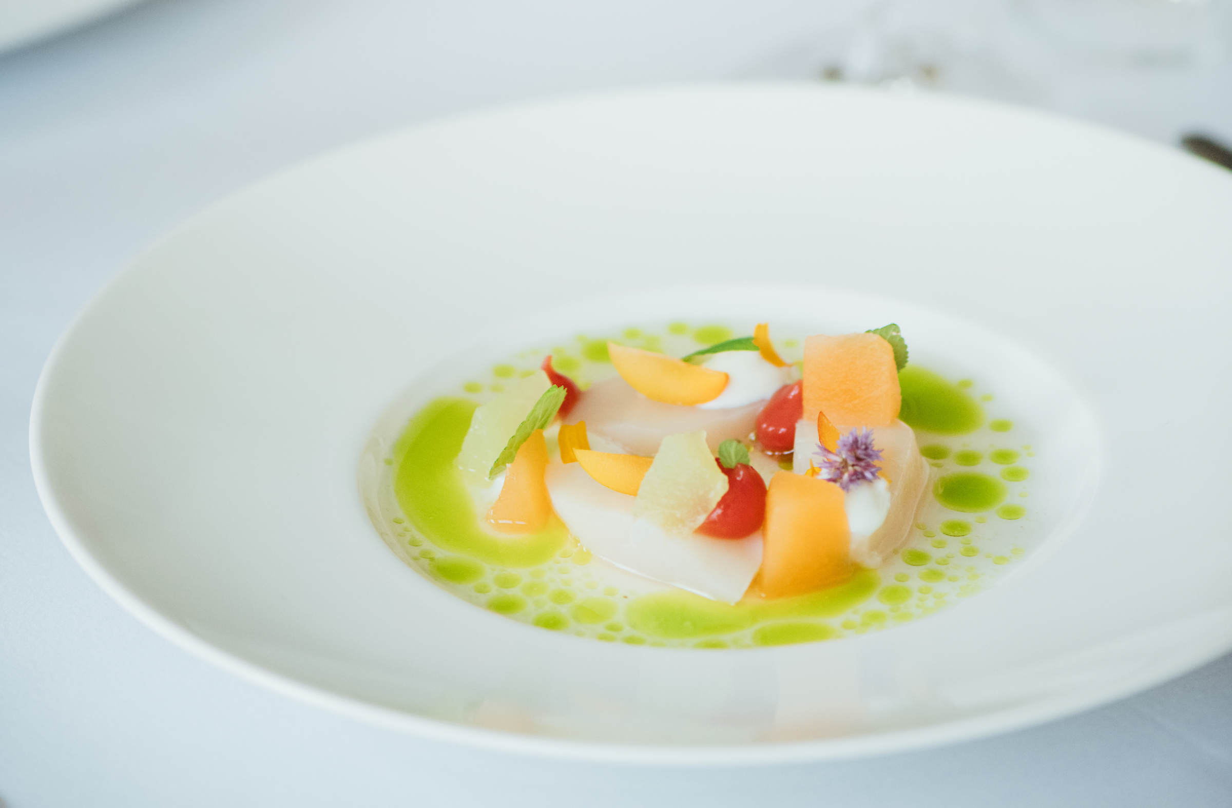 A plate of scallops with melon