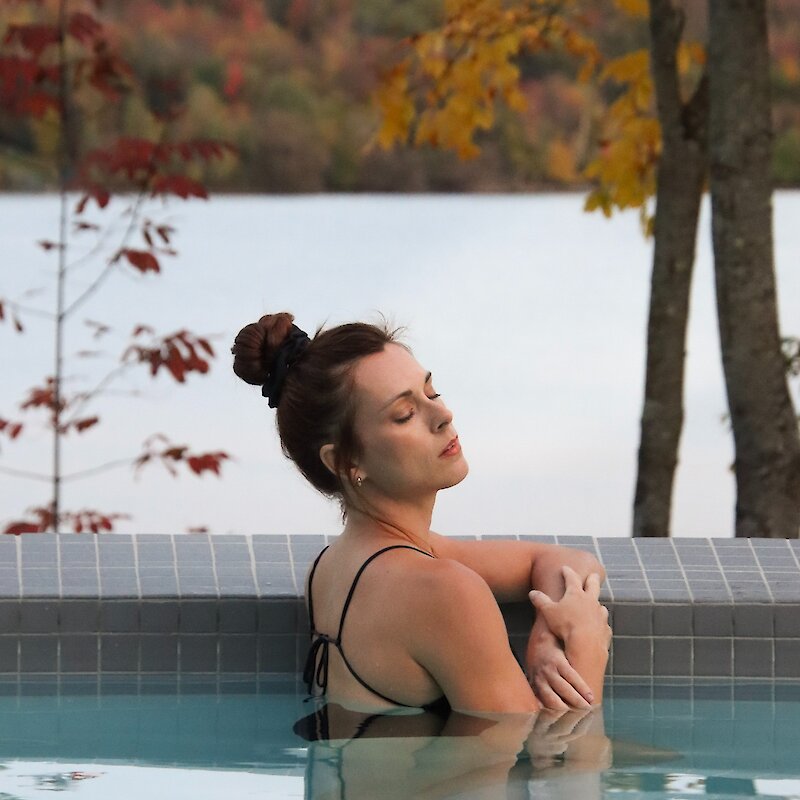 A woman relaxing on the edge of the pool.