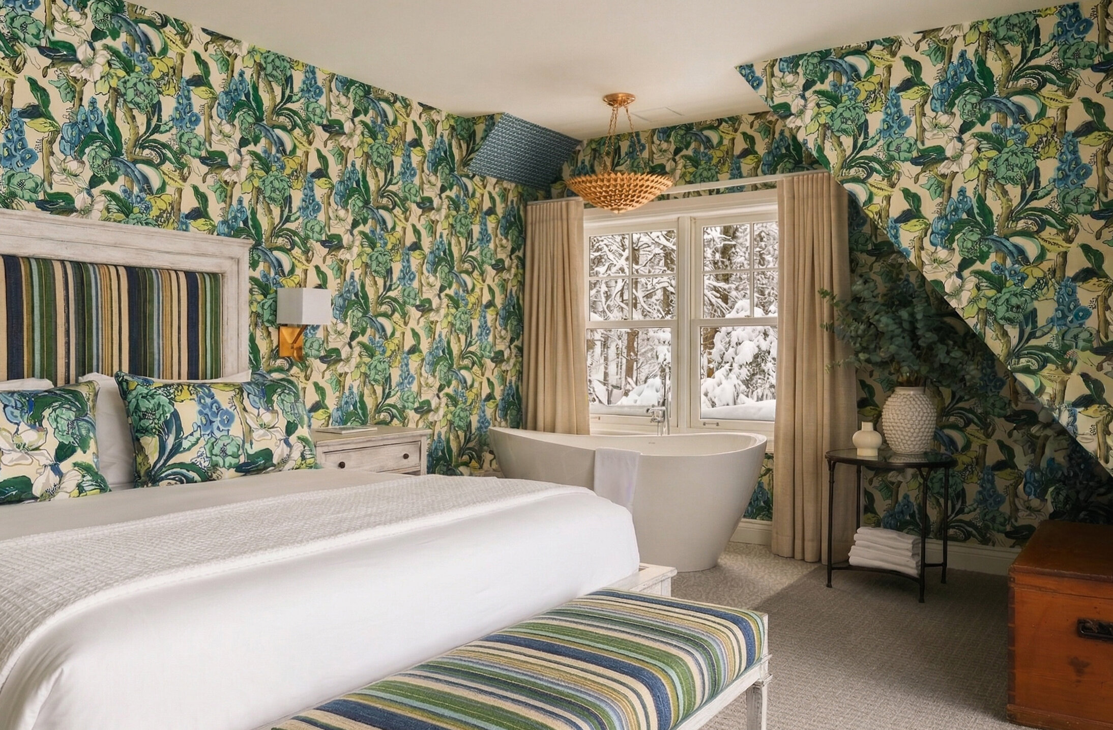 Chambre élégante avec lit king et baignoire autoportante près de la fenêtre, offrant une vue sur la nature environnante. Décor raffiné aux motifs botaniques et ambiance lumineuse.