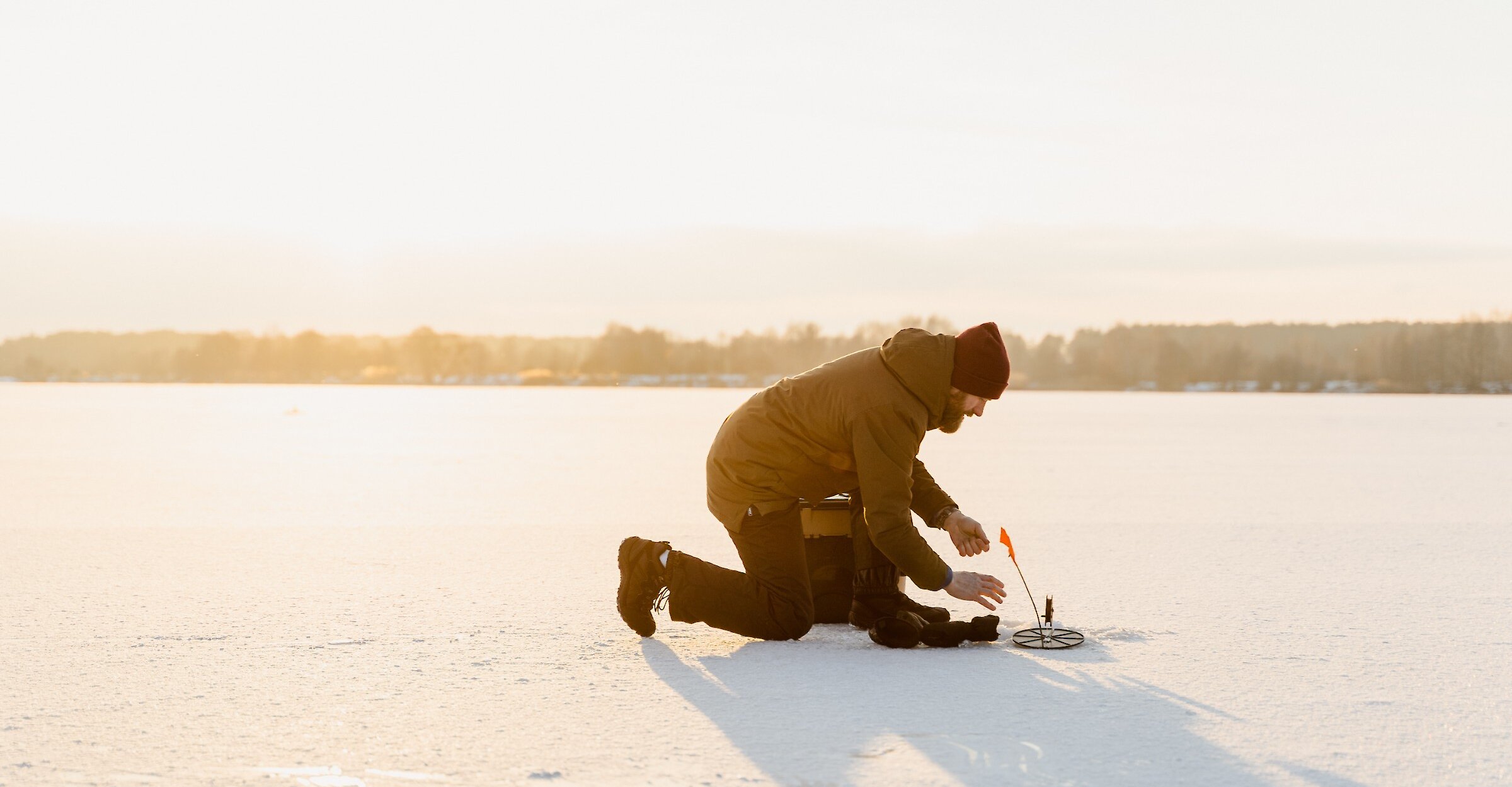 A man fishing on a frozen lake