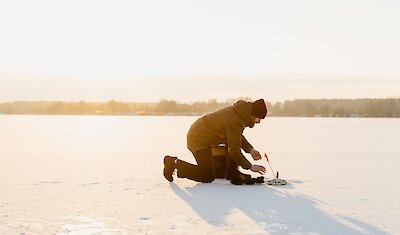 Un homme pêchant sur un lac gelé