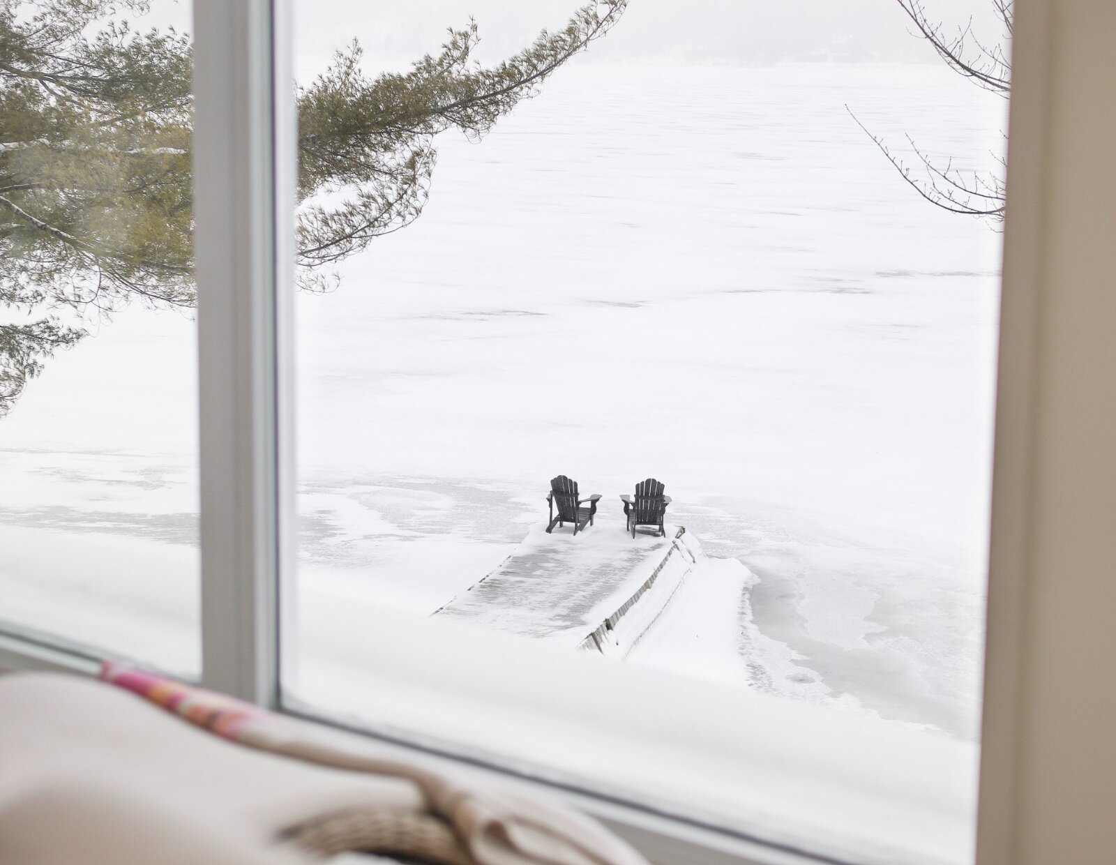 Deux chaises sur un quai au bord d'un lac en hiver